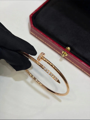 Cartier gold bracelet jewelry with sleek, polished design featuring a delicate chain and clasp, worn on a wrist.