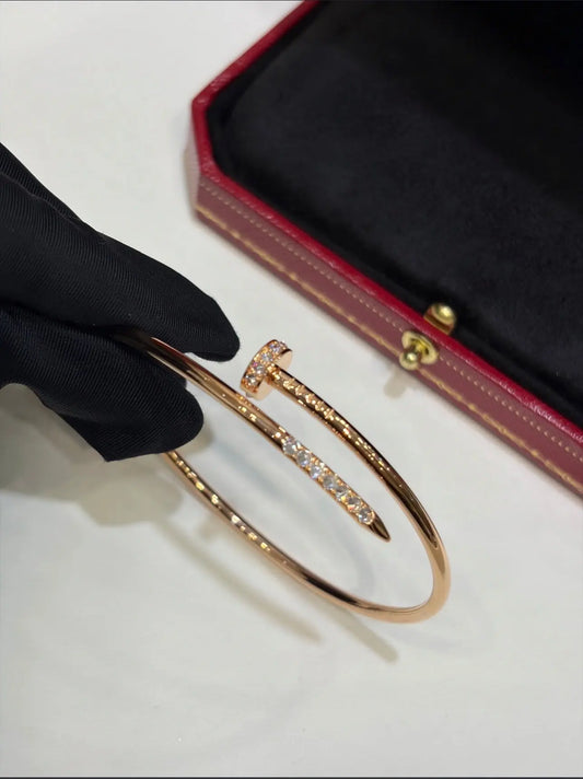 Cartier gold bracelet jewelry with sleek, polished design featuring a delicate chain and clasp, worn on a wrist.